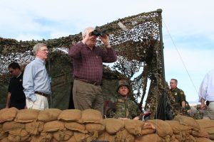 Rep. Price looking through binoculars at a military post.